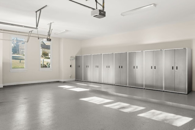 garage with a garage door opener and baseboards