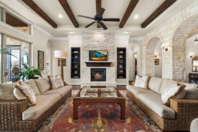 living room featuring wood finished floors, a ceiling fan, beam ceiling, decorative columns, and arched walkways