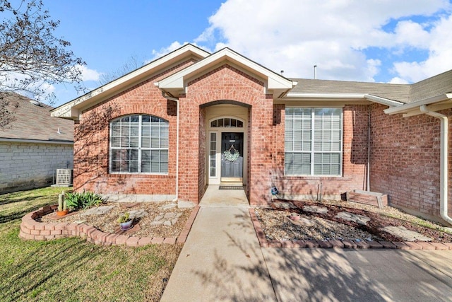 view of front of property with brick siding and central AC