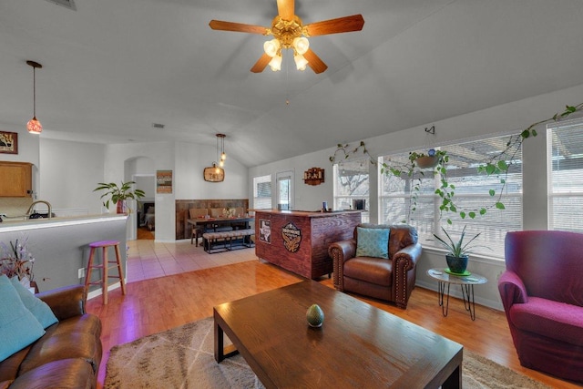 living room featuring lofted ceiling, light wood-type flooring, and ceiling fan