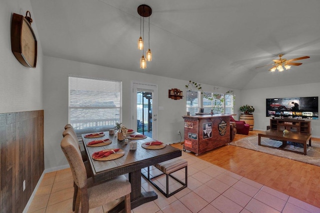 dining space with light tile patterned floors, a healthy amount of sunlight, a ceiling fan, and lofted ceiling