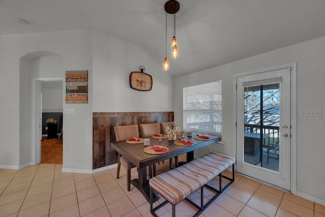 tiled dining room featuring lofted ceiling