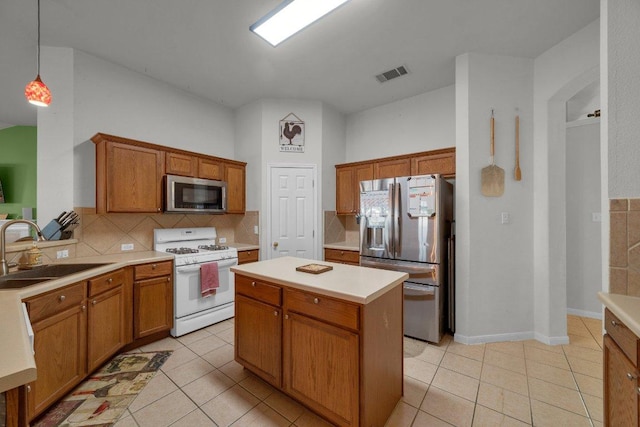 kitchen with light tile patterned floors, visible vents, a kitchen island, a sink, and stainless steel appliances