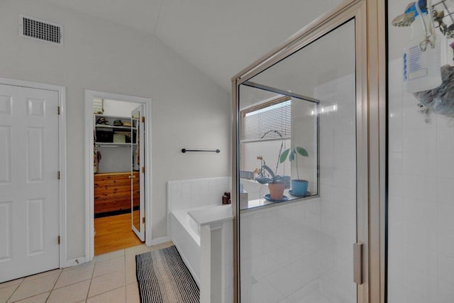 full bathroom with tile patterned floors, visible vents, a shower stall, lofted ceiling, and a bath