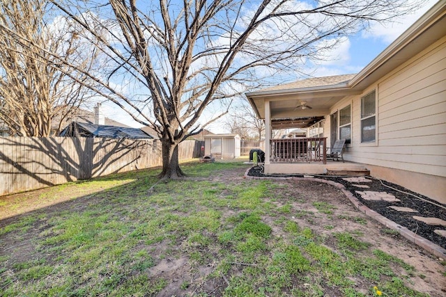 view of yard featuring a shed, fence private yard, an outdoor structure, ceiling fan, and a patio area