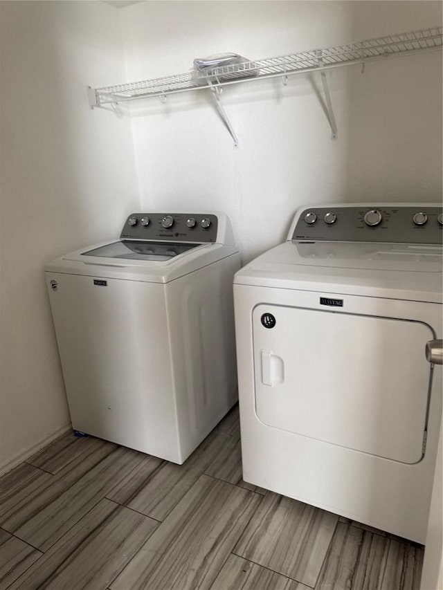 laundry area with laundry area, wood finish floors, and separate washer and dryer