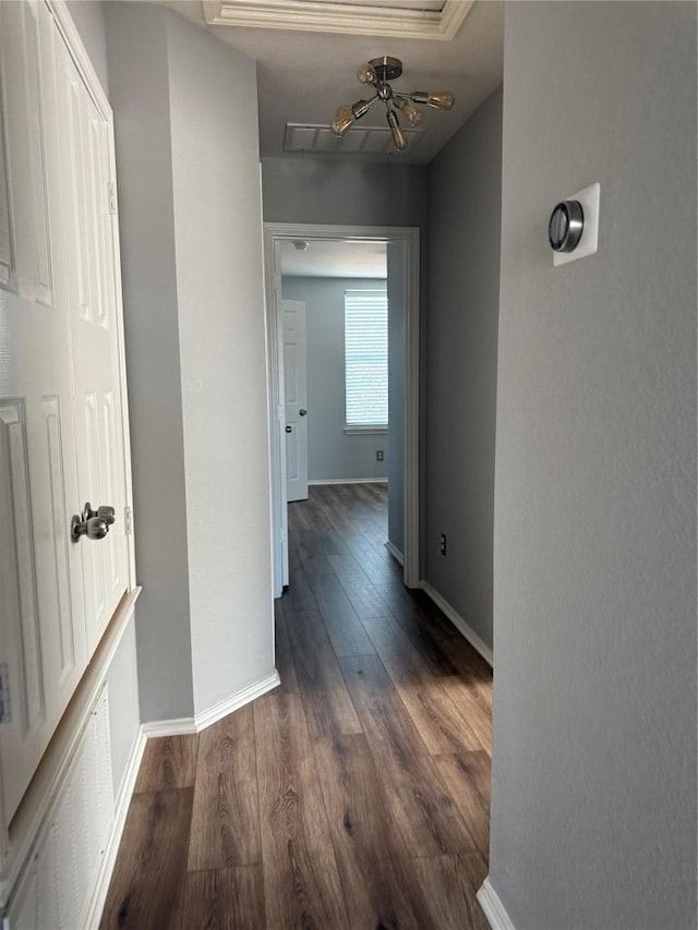 corridor with dark wood-type flooring and baseboards