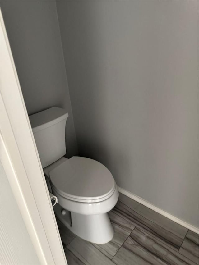 bathroom with baseboards and toilet