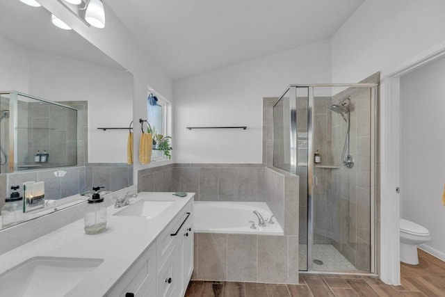 full bath featuring vaulted ceiling, a stall shower, wood finish floors, and a sink