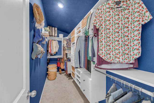 walk in closet featuring vaulted ceiling and carpet floors