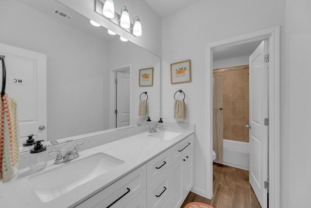 bathroom with double vanity, toilet, visible vents, and a sink