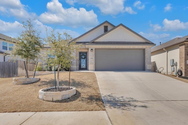 view of front of property featuring a garage, brick siding, driveway, and fence