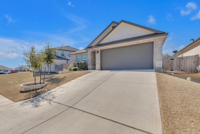 view of front of house featuring brick siding, fence, a garage, and driveway