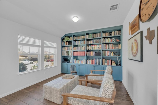 sitting room with visible vents, built in features, baseboards, and wood finished floors