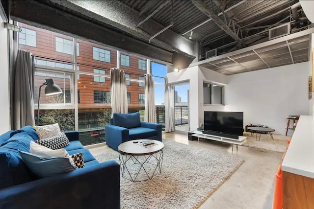 living area featuring visible vents and concrete flooring