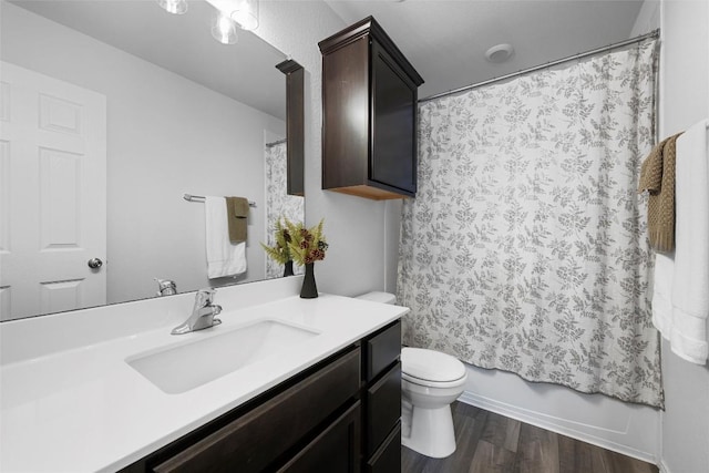 bathroom with vanity, toilet, wood finished floors, and shower / tub combo with curtain