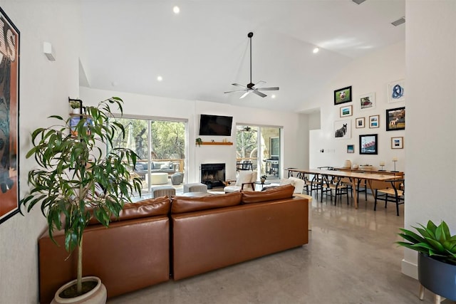 living area with visible vents, high vaulted ceiling, finished concrete flooring, a fireplace, and ceiling fan