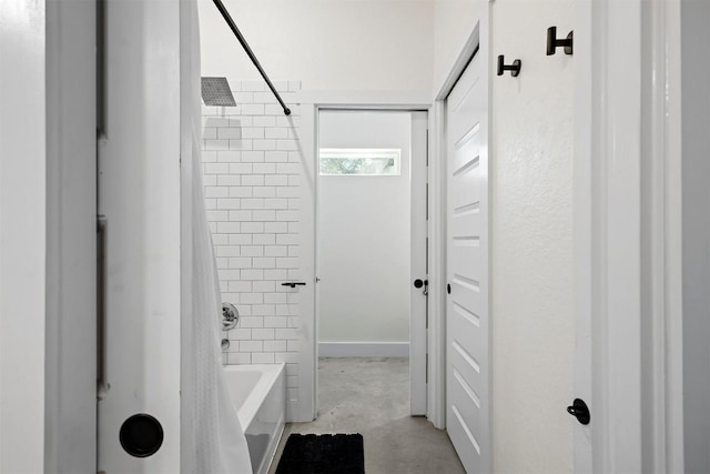 bathroom featuring tub / shower combination and unfinished concrete floors