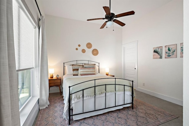 bedroom featuring baseboards, concrete floors, and a ceiling fan