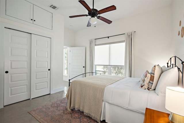 bedroom with visible vents, concrete floors, baseboards, a closet, and a ceiling fan