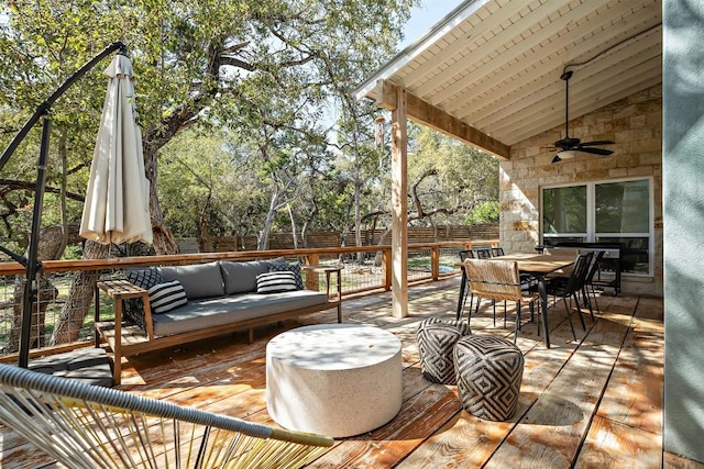 view of patio / terrace with an outdoor living space, a fenced backyard, a wooden deck, outdoor dining area, and ceiling fan