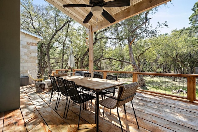 wooden terrace with outdoor dining area and a ceiling fan