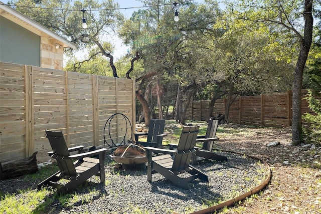 view of yard with fence and an outdoor fire pit