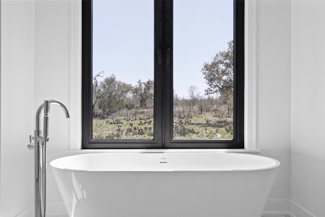 bathroom featuring baseboards and a soaking tub