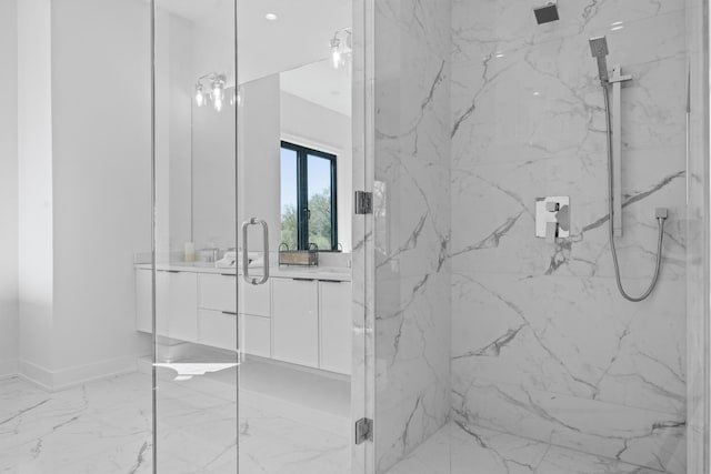 full bath featuring a marble finish shower, baseboards, marble finish floor, and vanity