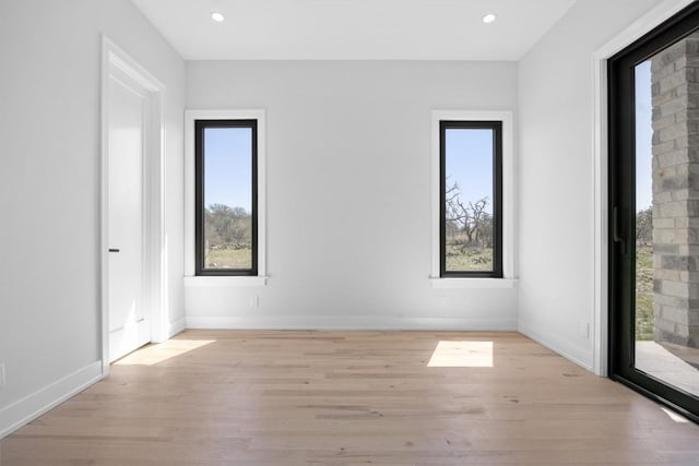 empty room with recessed lighting, light wood-style floors, and baseboards