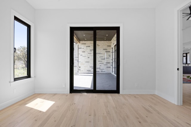 spare room featuring baseboards and wood finished floors