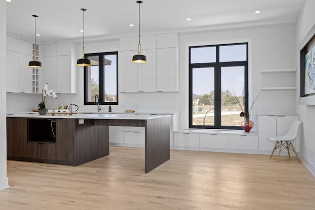 kitchen featuring plenty of natural light, modern cabinets, light countertops, and white cabinetry