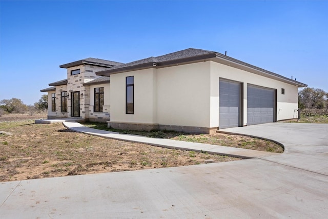 view of front of home with a garage, driveway, and stucco siding