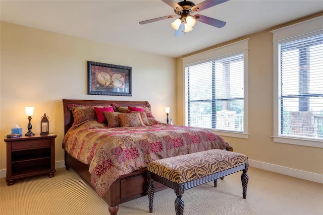 bedroom with a ceiling fan, baseboards, and light carpet