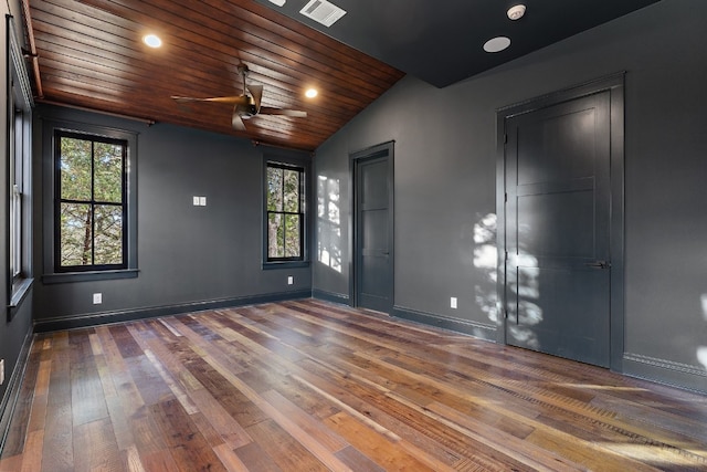 spare room featuring a wealth of natural light, visible vents, lofted ceiling, and hardwood / wood-style floors