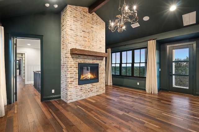 unfurnished living room featuring visible vents, dark wood finished floors, an inviting chandelier, a fireplace, and vaulted ceiling with beams