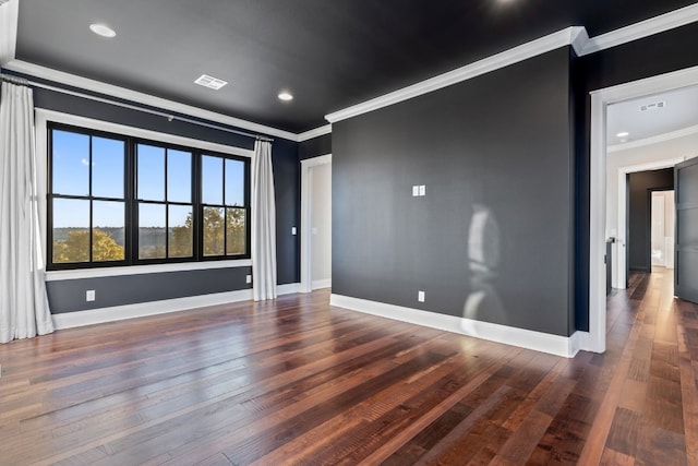 empty room with visible vents, baseboards, and hardwood / wood-style flooring