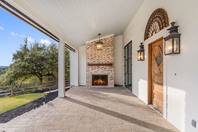 view of patio / terrace featuring an outdoor brick fireplace and fence