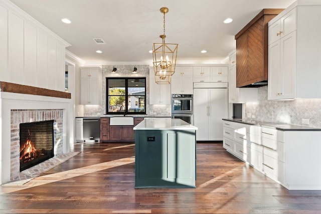 kitchen with visible vents, a sink, white cabinets, stainless steel appliances, and dark wood-style flooring