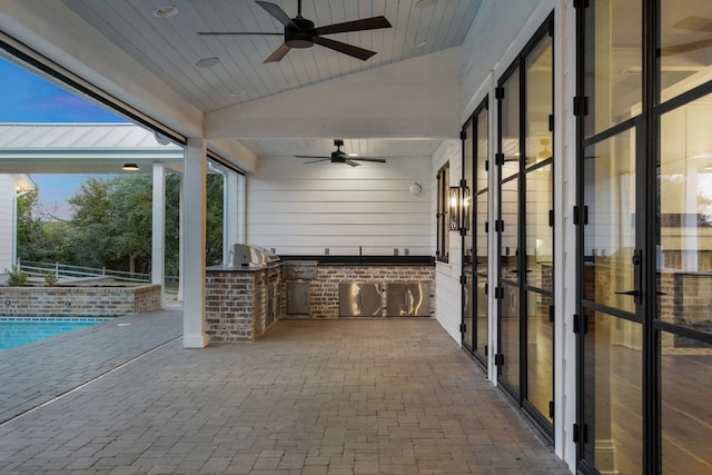 view of patio featuring fence, an outdoor kitchen, a pool with connected hot tub, ceiling fan, and a grill