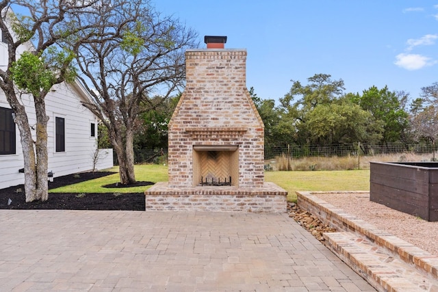 view of patio / terrace with fence and an outdoor brick fireplace