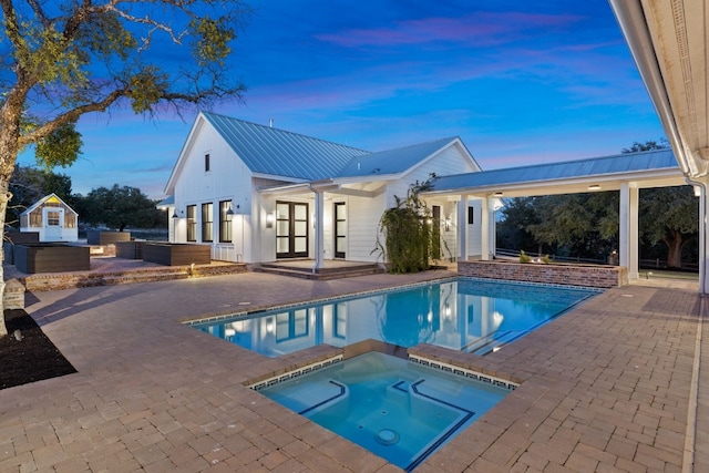 outdoor pool featuring an in ground hot tub and a patio