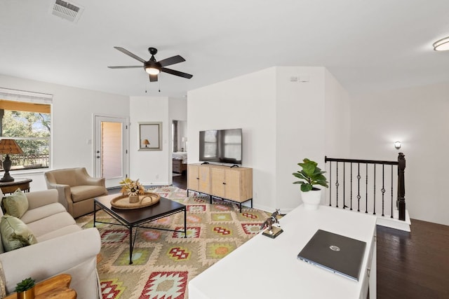 living room with visible vents, baseboards, ceiling fan, and wood finished floors