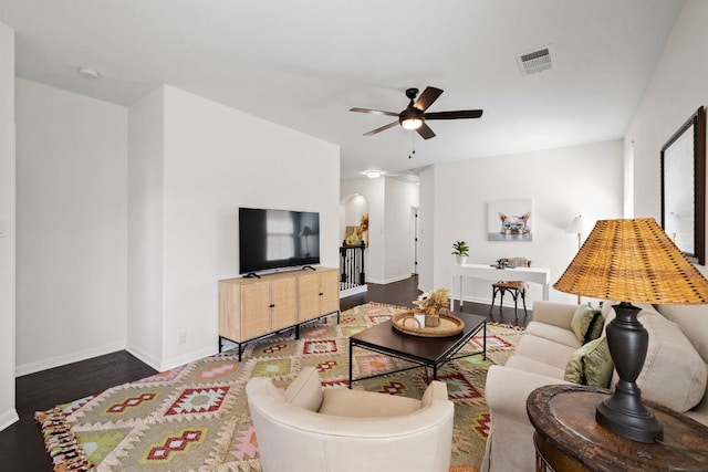 living room featuring visible vents, baseboards, ceiling fan, and wood finished floors