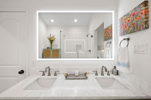 full bath featuring double vanity, tiled shower, and a sink