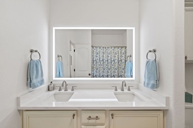 full bathroom with double vanity, a shower with curtain, and a sink