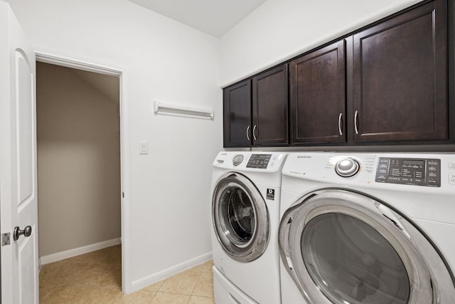 washroom featuring light tile patterned floors, baseboards, cabinet space, and independent washer and dryer