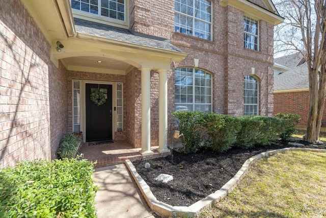 doorway to property featuring brick siding