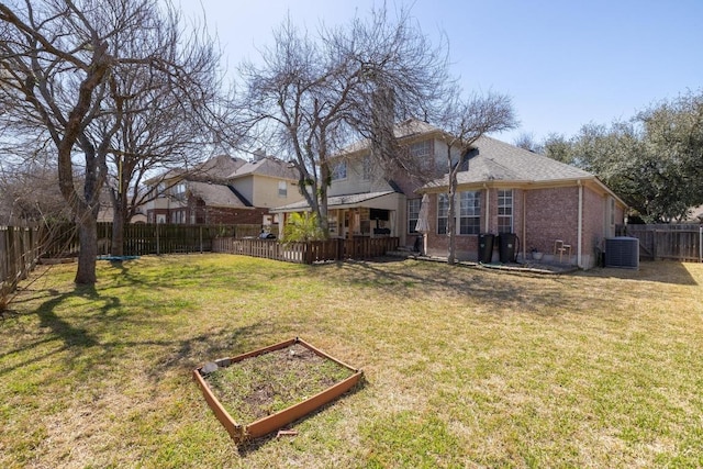 view of yard featuring a garden, a fenced backyard, and central AC