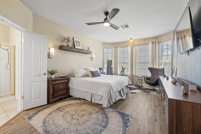 bedroom with visible vents, wood finished floors, and a ceiling fan